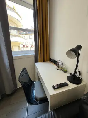 a desk with a lamp and a chair next to a window at Almada Downtown 201 in Porto
