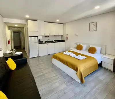 a bedroom with a large bed and a kitchen at Almada Downtown 201 in Porto