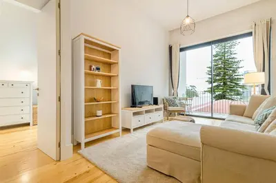 a living room with a couch and a tv and a window at Republica I by Innkeeper in Porto
