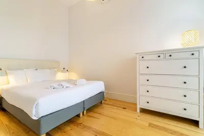 a bedroom with a white bed and a dresser at Republica I by Innkeeper in Porto