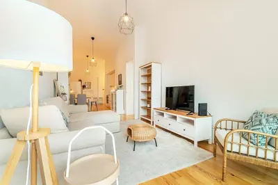 a living room with a white couch and a tv at Republica I by Innkeeper in Porto
