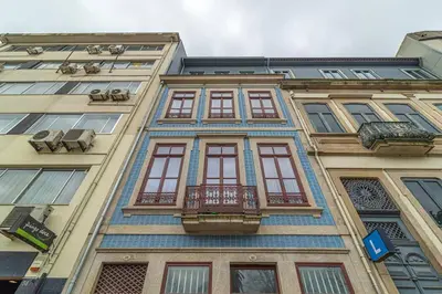 a tall building with windows and a balcony at Republica I by Innkeeper in Porto