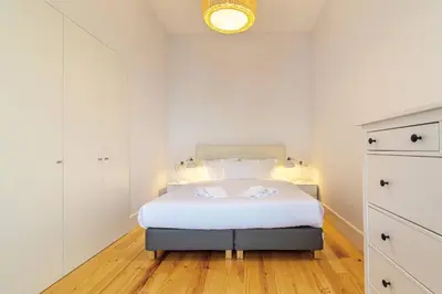 a white bedroom with a bed and a light at Republica I by Innkeeper in Porto