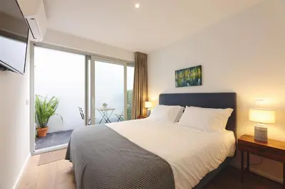 a bedroom with a large bed and a large window at RIBEIRA FLORES 59 Downtown Apartments in Porto