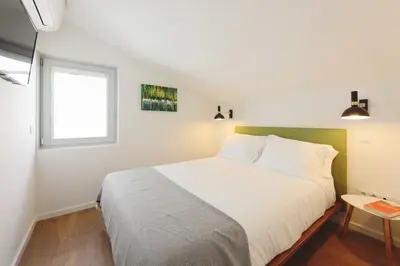 a bedroom with a large white bed with a window at RIBEIRA FLORES 59 Downtown Apartments in Porto
