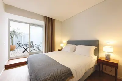 a bedroom with a large bed and a balcony at RIBEIRA FLORES 59 Downtown Apartments in Porto