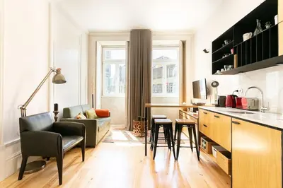 a kitchen and living room with a counter and chairs at Soprano Loft Porto Center - by Guest SPA in Porto
