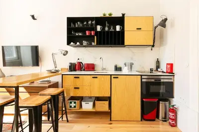 a kitchen with wooden cabinets and a table and chairs at Soprano Loft Porto Center - by Guest SPA in Porto