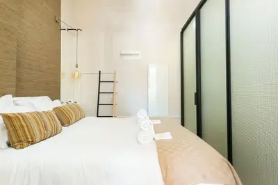 a bedroom with a large bed with white sheets and pillows at Soprano Loft Porto Center - by Guest SPA in Porto