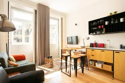 a living room with a kitchen with a table and a couch at Soprano Loft Porto Center - by Guest SPA in Porto