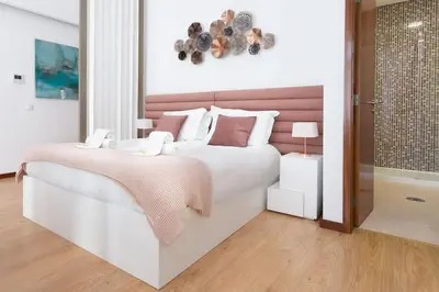 a white bedroom with a large bed and a bathroom at Valentino Loft Porto Center - by Guest SPA in Porto