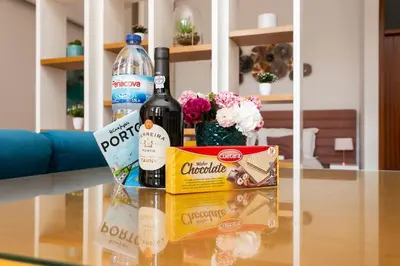 a glass table with two bottles of wine and a box at Valentino Loft Porto Center - by Guest SPA in Porto