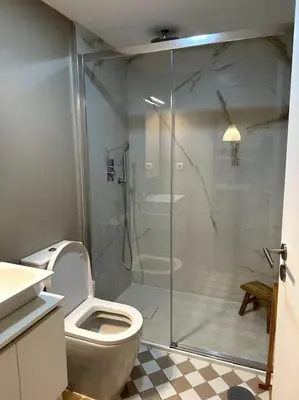 a bathroom with a toilet and a glass shower at Almada One in Porto
