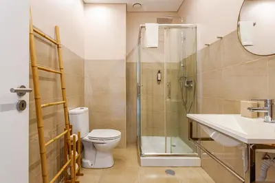 a bathroom with a shower and a toilet and a sink at Serpa Downtown Gaia in Vila Nova de Gaia
