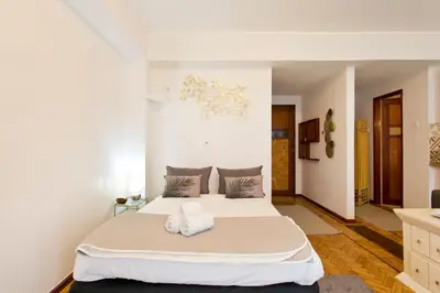a bedroom with a large white bed with towels on it at Aposentus - Downtown Bright Apartment in Porto