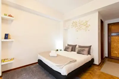 a bedroom with a large bed with white walls at Aposentus - Downtown Bright Apartment in Porto