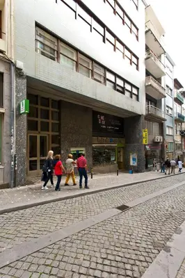a group of people walking down a street in front of a building at Aposentus - Downtown Bright Apartment in Porto