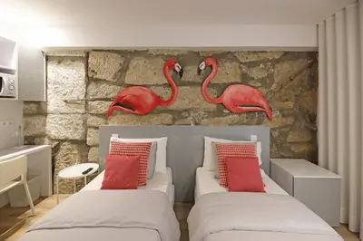 two red flamingos on the wall of a bedroom at FLH Porto Downtown GuestHouse in Porto