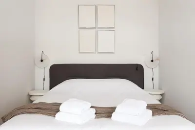 a bedroom with a white bed with towels on it at VIVA Merchant's Way in Porto