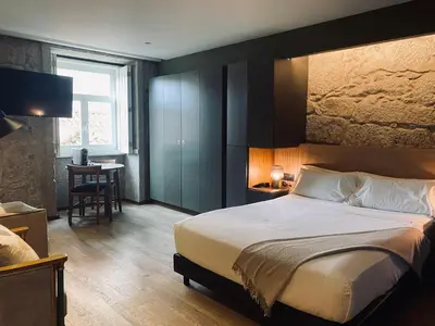 a bedroom with a large bed and a table at Oca Ribeira do Porto AT in Porto