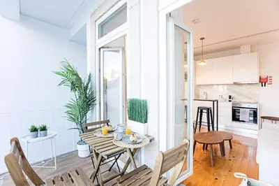 a kitchen and living room with a table and chairs at Wonderful Duplex W Private Patio & AC by LovelyStay in Porto