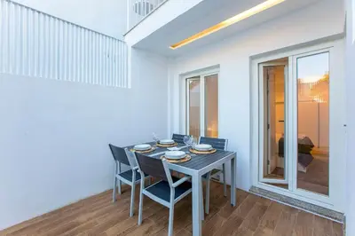 a dining room with a table and four chairs at Wonderful Duplex W Private Patio & AC by LovelyStay in Porto