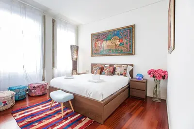 a bedroom with a large bed and a painting on the wall at GuestReady - Fantástico apt em Santa Catarina in Porto