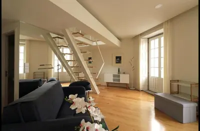 a living room with a couch and a staircase at Rua das Flores Neighborhood in Porto