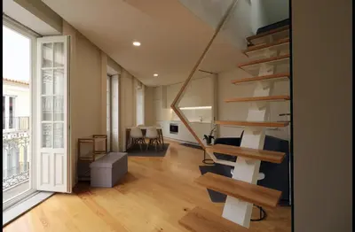 a living room with a spiral staircase in a house at Rua das Flores Neighborhood in Porto