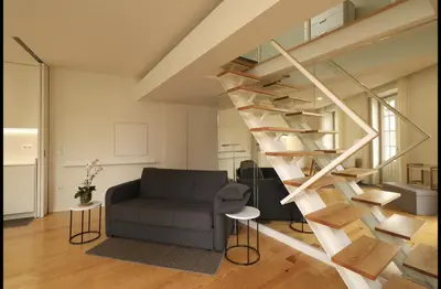 a staircase in a living room with a couch and a chair at Rua das Flores Neighborhood in Porto