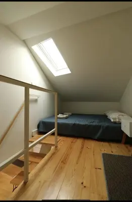 a attic bedroom with a bed and a skylight at Rua das Flores Neighborhood in Porto