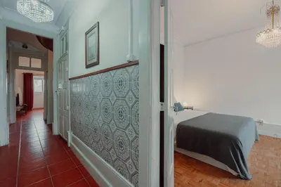 a bedroom with a bed in a room with a wall at Alegria Four - Bedroom House in Porto