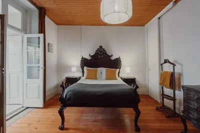 a bedroom with a black bed with orange pillows at Alegria Four - Bedroom House in Porto