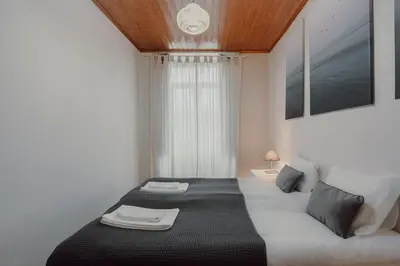 a bedroom with a black and white bed and a window at Alegria Four - Bedroom House in Porto