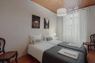 a bedroom with a bed with two towels on it at Alegria Four - Bedroom House in Porto