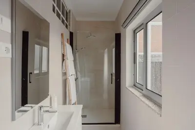a white bathroom with two sinks and a shower at Alegria Four - Bedroom House in Porto