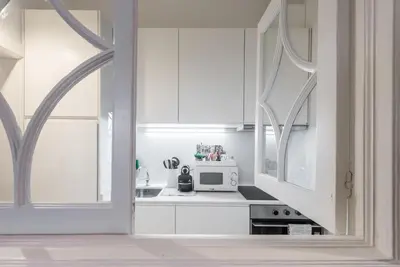 a kitchen with white cabinets and a microwave at GuestReady - Rustic urban retreat in Porto