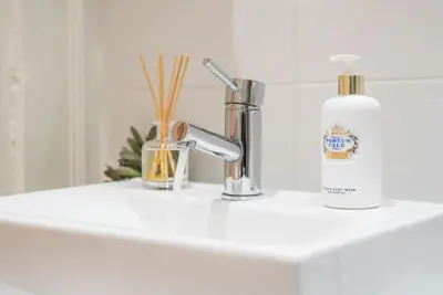 a bathroom sink with a faucet and a bottle of soap at GuestReady - Rustic urban retreat in Porto