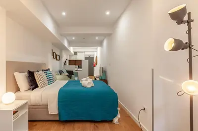 a bedroom with a bed with a blue blanket at Underground Batalha Studios in Porto