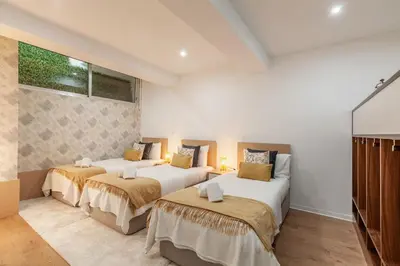 two beds in a room with white walls at Underground Batalha Studios in Porto