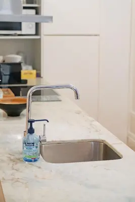 a bottle of soap sitting on a kitchen sink at Bolhão Studio, Porto in Porto