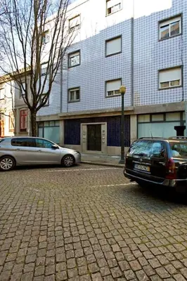 two cars parked in a parking lot in front of a building at APOSENTUS - Serenity 1D in Porto