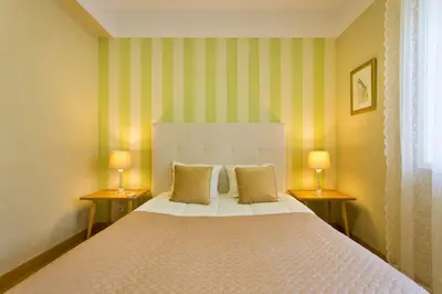 a bedroom with a large bed with two lamps at APOSENTUS - Serenity 1D in Porto