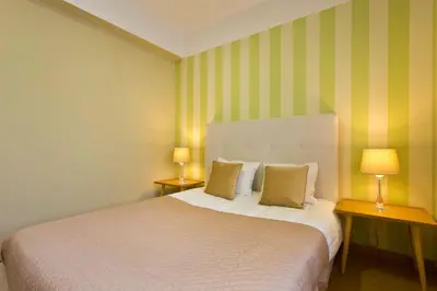 a bedroom with a large bed with two lamps at APOSENTUS - Serenity 2D in Porto