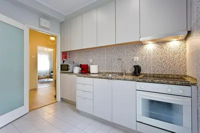 a kitchen with white cabinets and a counter top at APOSENTUS - Serenity 2D in Porto