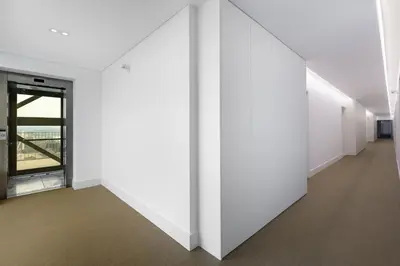 an empty hallway with white walls and a window at Dragão Rooftop in Porto