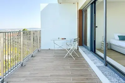 a balcony with a table and a desk on it at Dragão Rooftop in Porto
