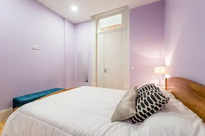 a bedroom with purple walls and a bed with two pillows at GuestReady - Seaside getaway in Porto in Porto
