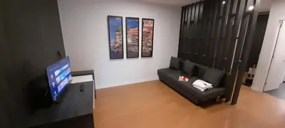 a living room with a black couch and a flat screen tv at 504 New Apartment Galé in Porto