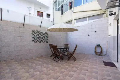 a patio with a table and chairs and an umbrella at APOSENTUS - Serenity Terrace in Porto